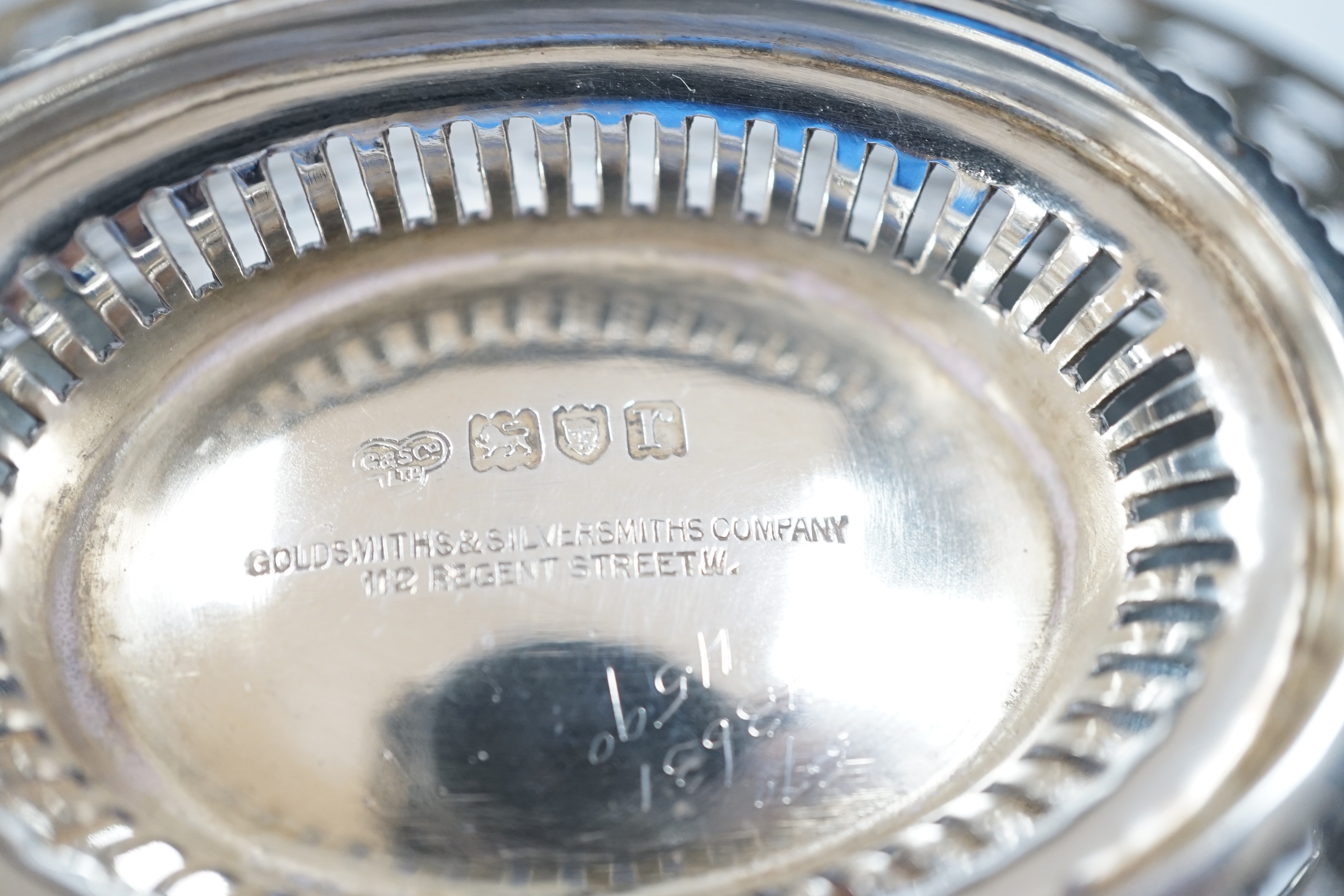 A George V pierced silver oval sweetmeat dish, with swing handle and fretwork decoration, Goldsmiths & Silversmiths Co., London 1912, 16cm, 174 grams